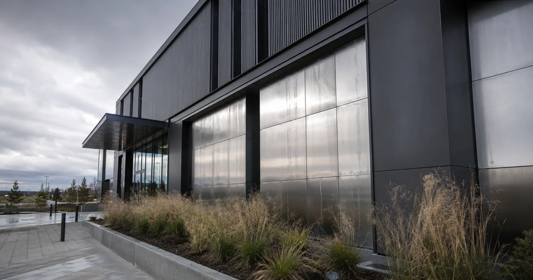 Exterior view of a modern commercial building with sheet metal facade panels exposed to outdoor weather