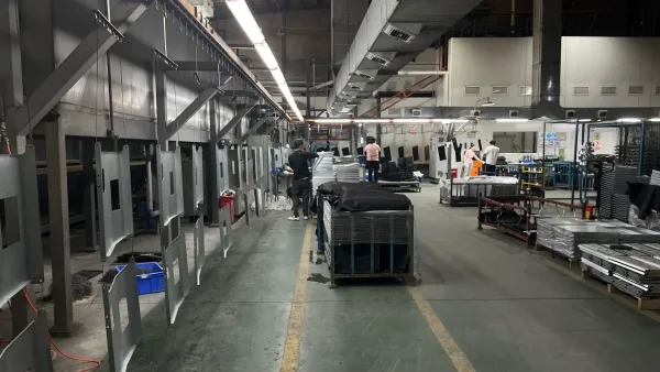 Powder coating line with barbecue grill components suspended on the conveyor at Baoxuan factory
