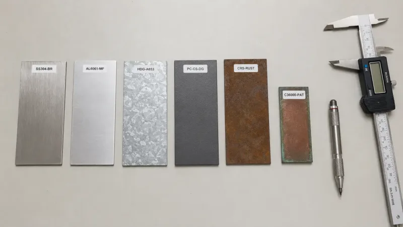Labeled metal test samples arranged on a laboratory workbench for material property evaluation