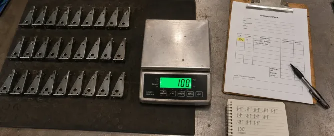 Sheet metal parts organized in trays with a clipboard checklist beside them for quantity verification