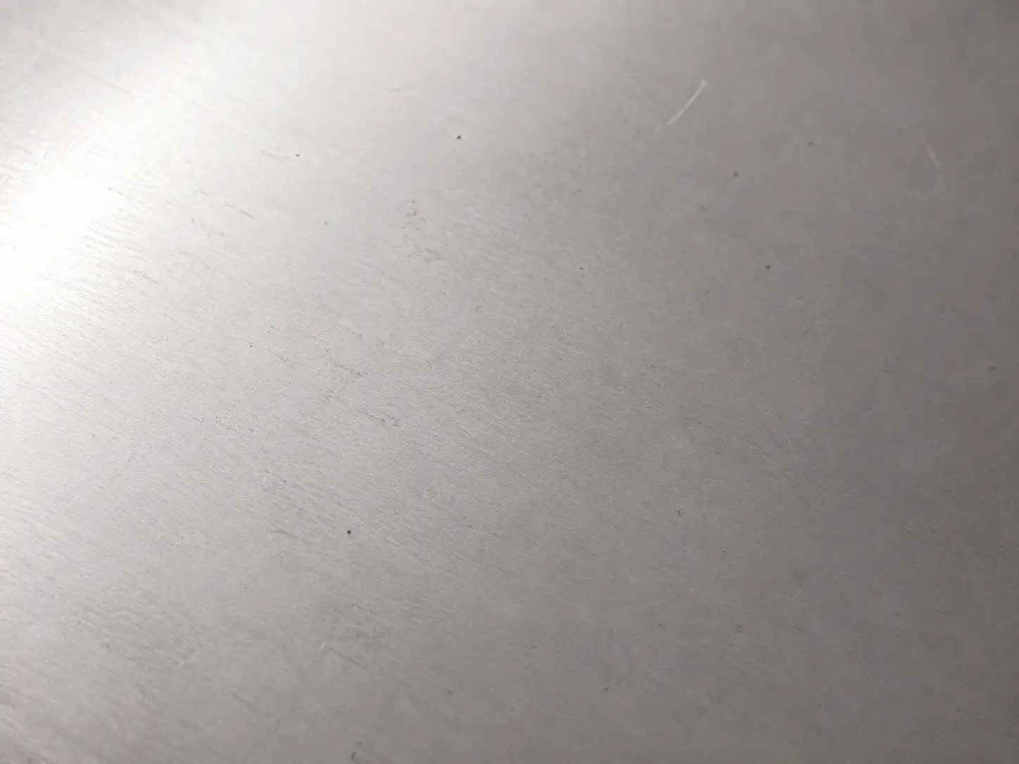 Cold-rolled carbon steel sheet showing minor scratches, indentations and light surface imperfections
